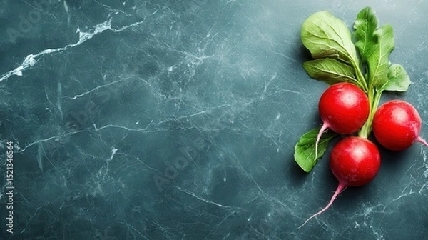 Fototapeta This image showcases three vibrant red radishes with leafy greens sitting on a dark, textured surface, highlighting their freshness and natural beauty for culinary presentations.