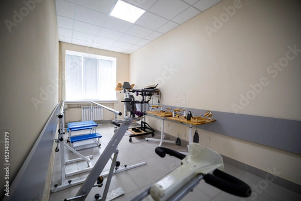Fototapeta A rehabilitation room features diverse exercise and physical therapy equipment, including a gait training machine, a treadmill, a stationary bicycle, manipulative tools, designed for patient recovery.