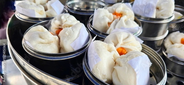 Obraz Stuffed steamed buns arranged in Stainless steel steamer for heating and selling. Steamed buns with minced pork filling, salted egg pork filling, Dough shaped into balls, filled with pig various.
