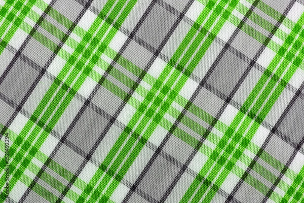Fototapeta The texture of linen fabric in a large cage of blue, green, brown and white. Scottish tailoring material. Checkered fabric