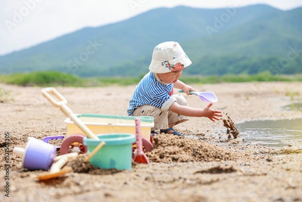 Obraz  강가 모래사장에서 노는 귀여운 유아