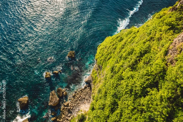 Fototapeta Ocean with waves crashing on stones, view from cliff coastline