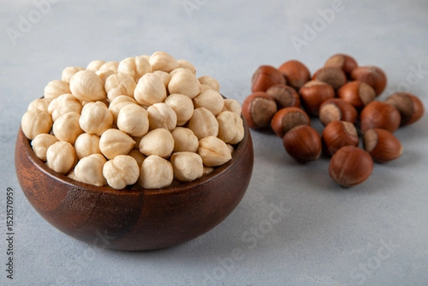Fototapeta Heap of peeled and shelled hazelnuts on concrete background,closeup