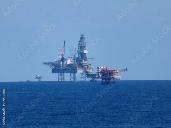 Obraz Oceanic Oil Platforms Under Vast Azure Sky AStunning View Of Offshore Drilling Rigs Against The Deep Blue Sea.Tranquil And Imposing Presence