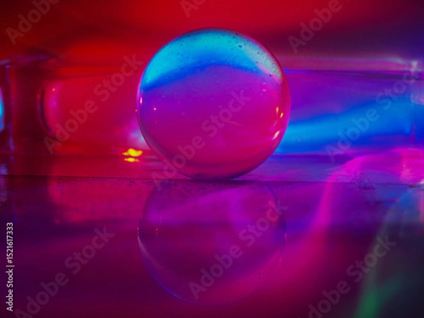 Fototapeta A clear glass ball is sitting on a pedestal. Colorful background. Abstract graphic background. Light effect. Planet in a space mood and feel.