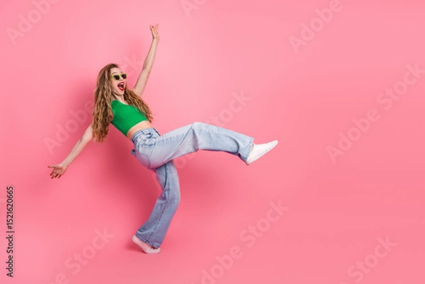 Fototapeta Stylish young woman in trendy casual attire joyfully posing against a vibrant pink backdrop, expressing happiness and confidence