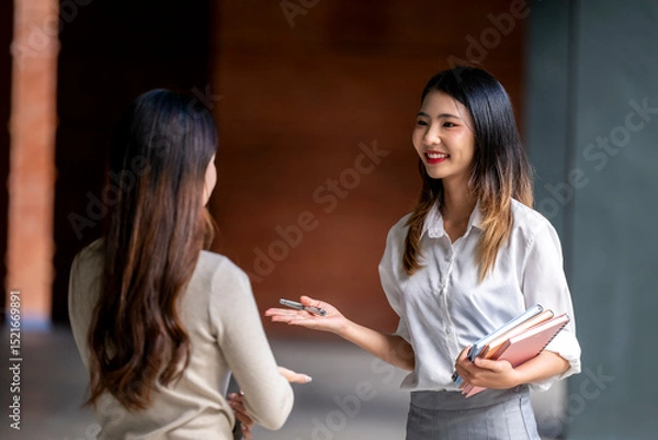 Fototapeta Two women are talking in a hallway