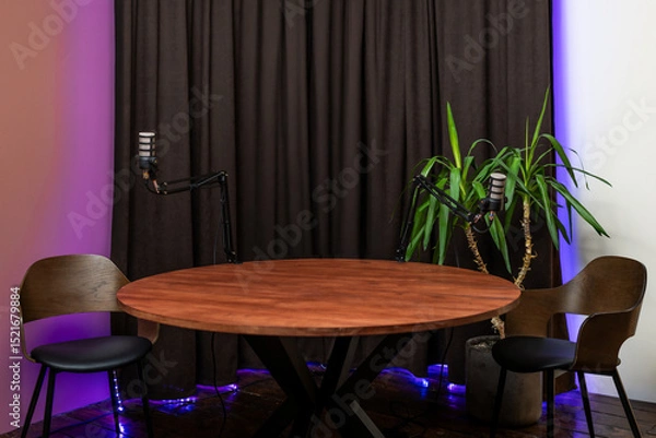 Fototapeta Discussion setup with microphones and headphones for podcasting in a cozy studio environment