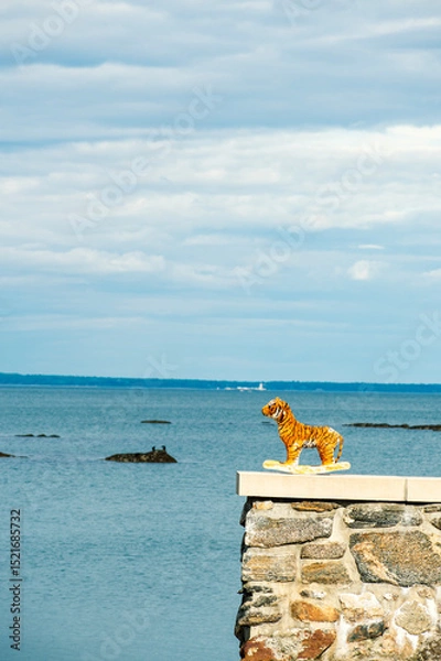 Obraz A toy tiger on a ledge with the ocean in the background 