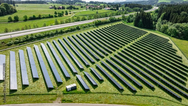 Fototapeta Große Freiflächen-PV Anlage entlang einer Autobahn im Sonnenschein, Luftbild.