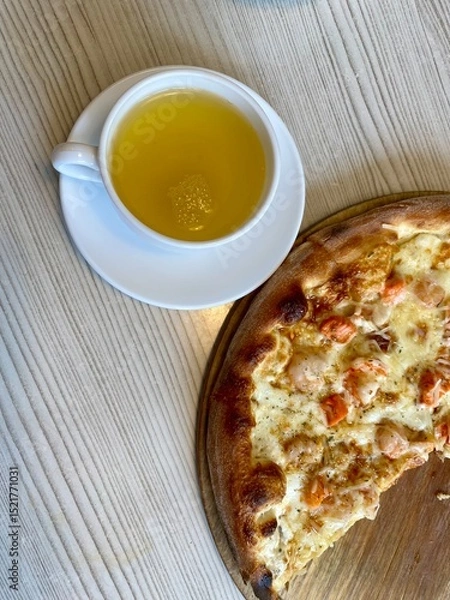 Obraz a cup of tea and pizza are on the table