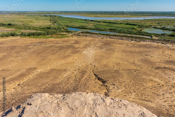 Obraz View of the Turkmenistan and Uzbekistan border with the Amu Darya river. Turkmenistan starts with the mountain in the  background