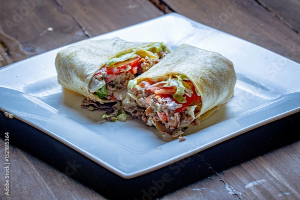 Fototapeta Mexican style tortilla wrap with beef and tomatoes and lettuce.