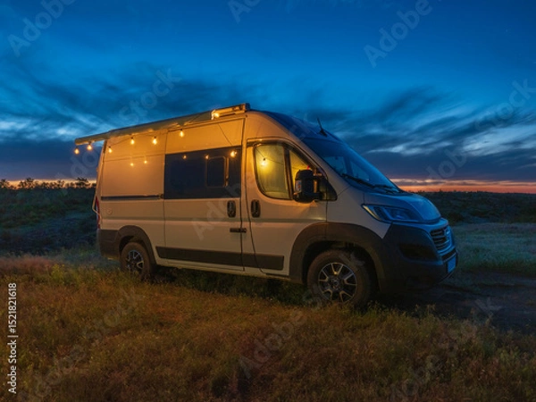 Obraz view to white camper van with night lights in twilight night sky with copy space