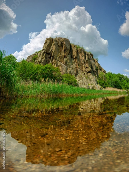 Obraz portrait view to granite rock on river in canyon under sky with huge cloud