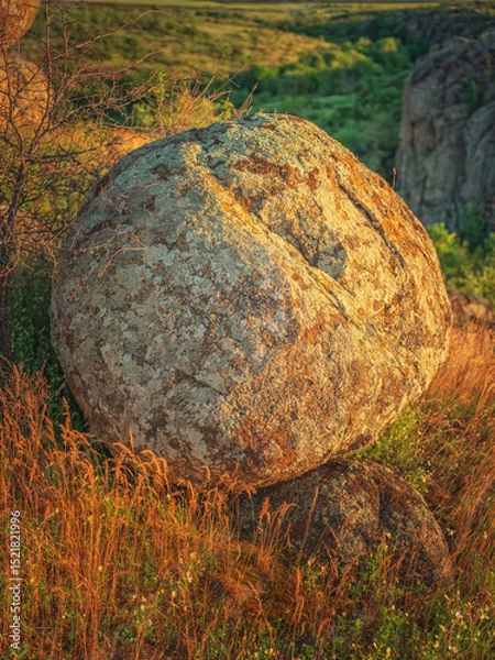 Obraz portrait view to huge round granite boulder in golden light of sun