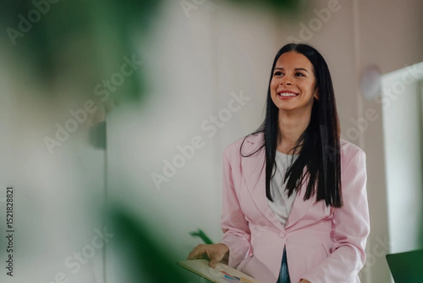 Fototapeta Smiling businesswoman holding charts and presenting successful results