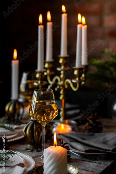 Obraz Rustic elegant table decor for christmas family dinner. Center piece with white candle, pine cone, fir tree branches. Zero waste eco-friendly home decoration. Cozy atmosphere, wooden background.