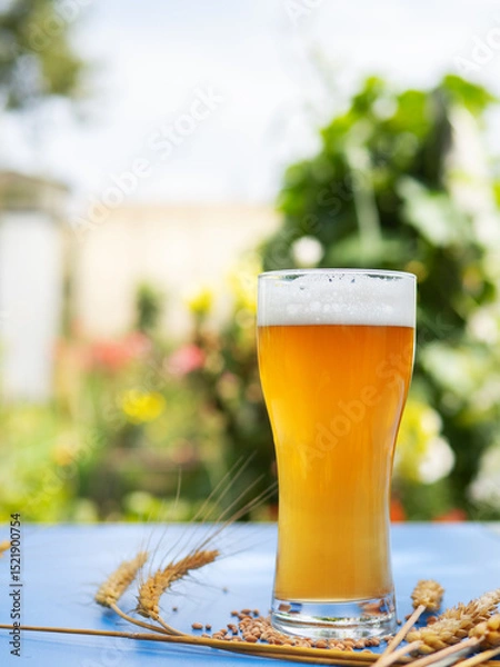 Fototapeta Cold beer glass on table in garden
