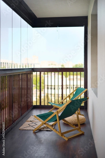 Fototapeta spacious and bright balcony with upholstered chairs, stylish and modern glazing, clear sunny weather