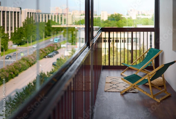 Fototapeta spacious and bright balcony with upholstered chairs, stylish and modern glazing, clear sunny weather