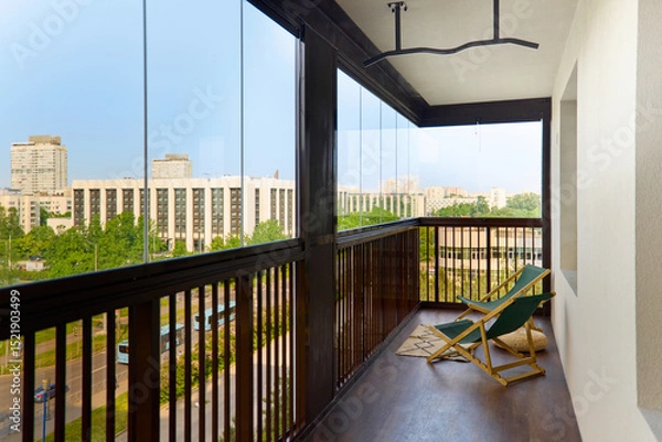 Fototapeta spacious and bright balcony with upholstered chairs, stylish and modern glazing, clear sunny weather