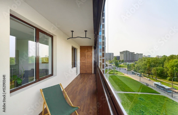 Fototapeta spacious and bright balcony with upholstered chairs, stylish and modern glazing, clear sunny weather