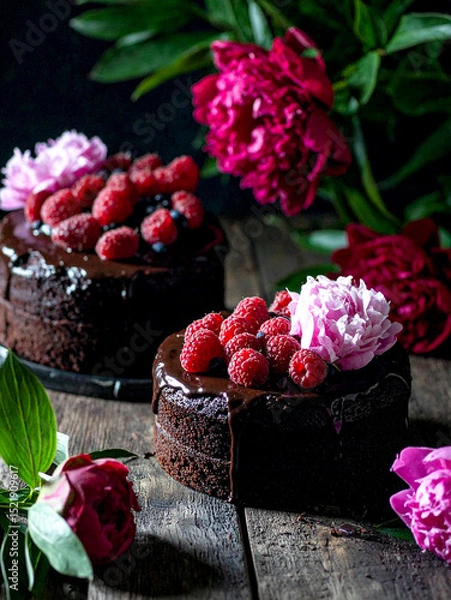 Obraz Luxurious chocolate cakes garnished with assorted berries and mint, presented on a contrasting black backdrop.