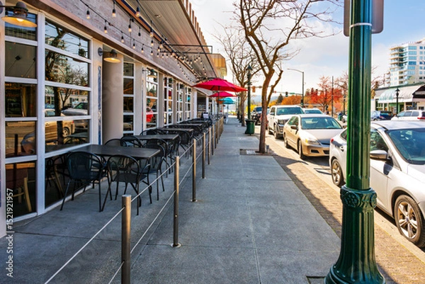 Fototapeta Rows of sidewalk cafes along Sherman Avenue with the lake in the distance in downtown Coeur d'Alene, Idaho.