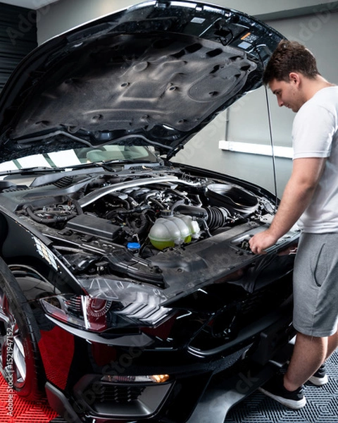 Obraz tecnico mecanico revisando motor con capot levantado