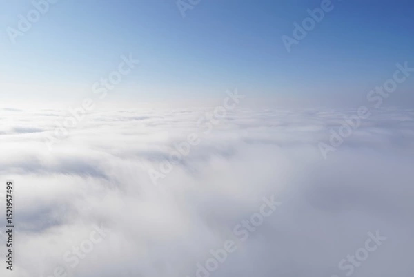 Fototapeta Vast sea of dense white clouds beneath a clear blue sky creating a serene and peaceful atmosphere