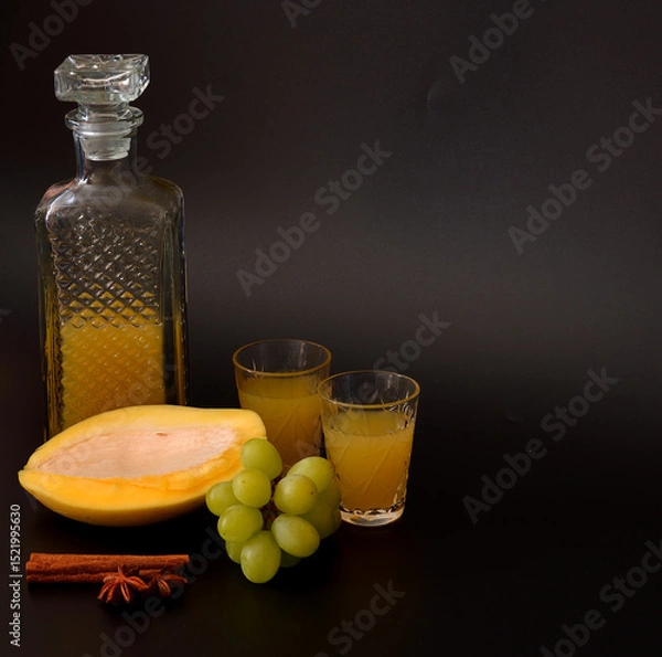 Obraz Fruit liqueur made from green grapes and mango with cinnamon and anise on a black background.