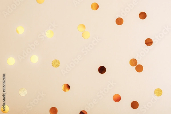 Fototapeta Golden confetti scattered on a soft beige background, texture