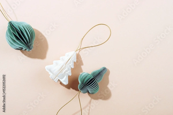 Fototapeta Paper Christmas ornaments on beige background with shadows. Top view, flat lay, copy space