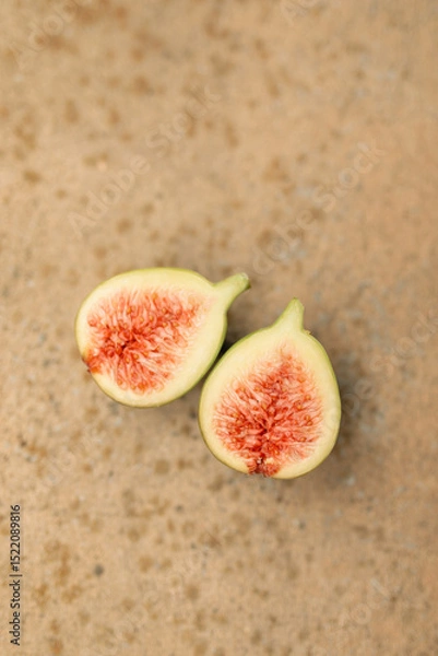 Fototapeta Flat lay image of fig fruit cut in half on textured background