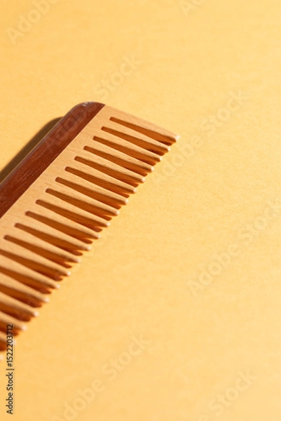 Fototapeta Close up of eco wooden comb at yellow background, show detail , copy space, hair care routine