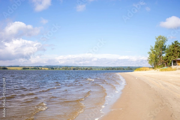 Obraz Serene beach landscape with gentle waves lapping against sandy shore under a clear blue sky