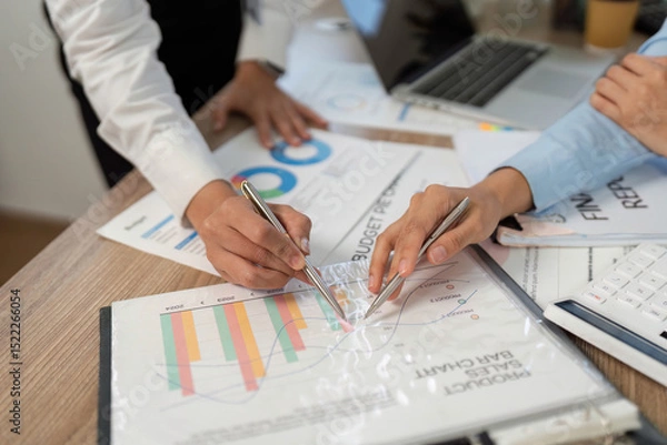 Obraz Financial Analysis. Close-up of hands reviewing budget charts and graphs at desk.