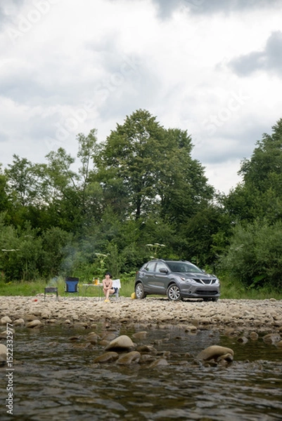 Obraz Camping by the River with SUV and Campfire