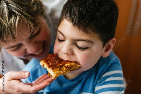 Fototapeta Mother sharing food with son with disability with microdeletion syndrome