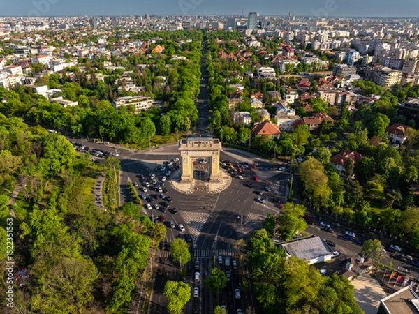 Fototapeta Aerial Bucharest. Arch of Triumph, Kiseleff boulevard and Herastrau Park in an aerial photo taken in the north part of Bucharest, Romania, during a summer day. Bucharest from above.
