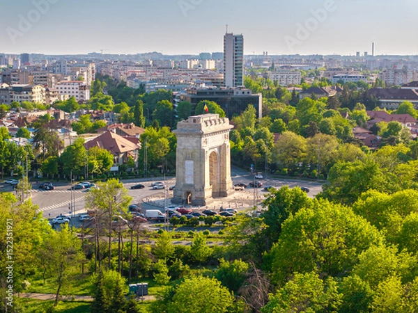 Fototapeta Aerial Bucharest. Arch of Triumph, Kiseleff boulevard and Herastrau Park in an aerial photo taken in the north part of Bucharest, Romania, during a summer day. Bucharest from above.
