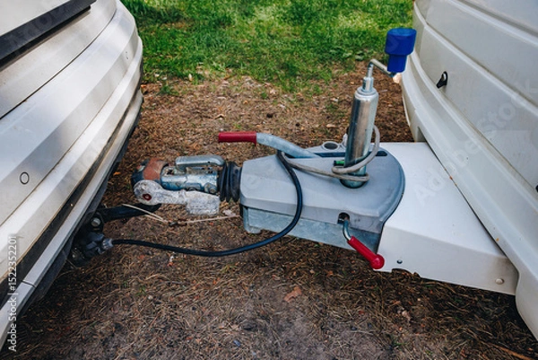 Fototapeta Hooking up caravan to a car. Сouple a trailer (i.s., hooked) into a ball-type tow hitch. Trailer coupling for caravans