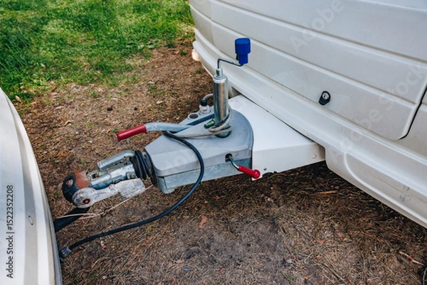 Fototapeta Hooking up caravan to a car. Сouple a trailer (i.s., hooked) into a ball-type tow hitch. Trailer coupling for caravans