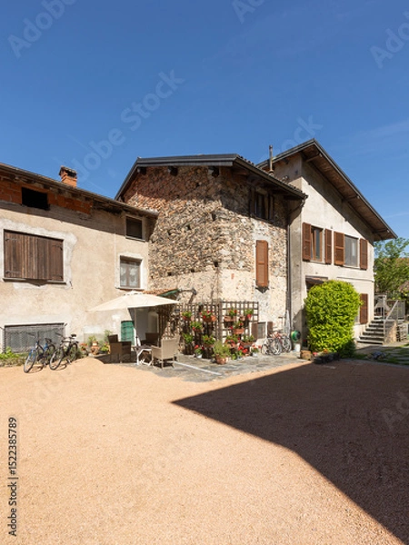 Fototapeta Connected holiday homes, Italian style with a large front yard and bicycles parked.