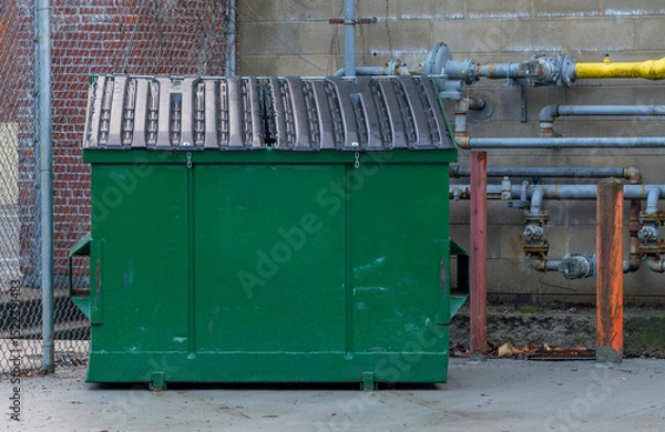 Fototapeta large green commercial dumpster for trash and recycling
