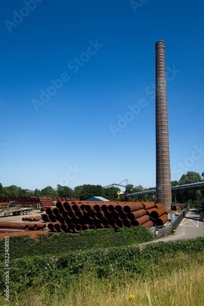Fototapeta Spijk Netherlands - 7 July 2023 - Former brick factory along the river Rhine in Spijk the Netherlands is producing large steel metal pipes