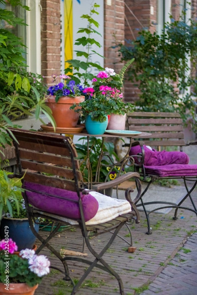 Fototapeta Deventer the Netherlands 19.05.2025 A pink metal table and chairs against the background of a wooden wall in the Dutch city of Deventer. High quality photo. High quality photo