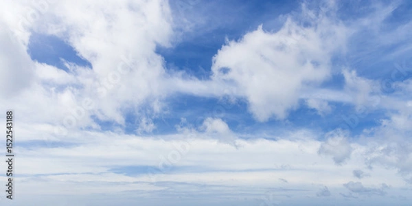 Obraz Different types of white clouds scatter across a blue sky, photo panorama