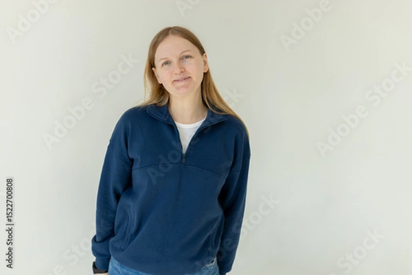 Obraz Pretty smiling joyfully female, dressed casually, looking with satisfaction at camera, being happy. Studio shot of beautiful woman isolated against blank studio wall.